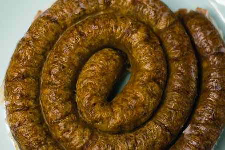 Delicious baked homemade sausage on a plate on a dark background, preparation for celebrating Easter in the family.の写真素材