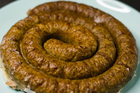 Delicious baked homemade sausage on a plate on a dark background, preparation for celebrating Easter in the family.の写真素材