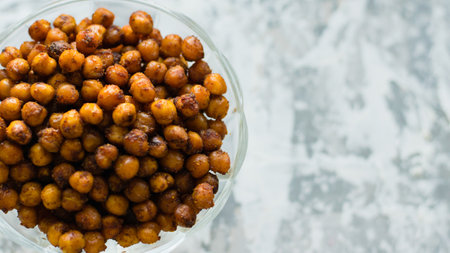 Delicious baked chickpeas in a transparent bowl on a light background with space for text flatlay. Healthy eating conceptの写真素材