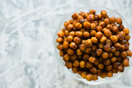Delicious baked chickpeas in a transparent bowl on a light background with space for text flatlay. Healthy eating conceptの写真素材