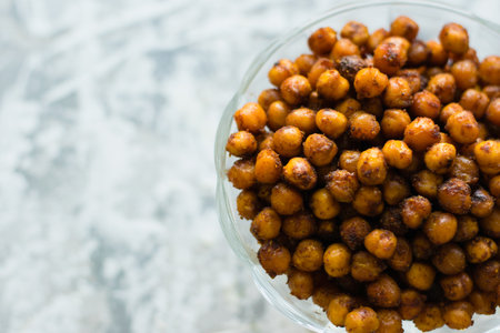 Delicious baked chickpeas in a transparent bowl on a light background with space for text flatlay. Healthy eating conceptの写真素材