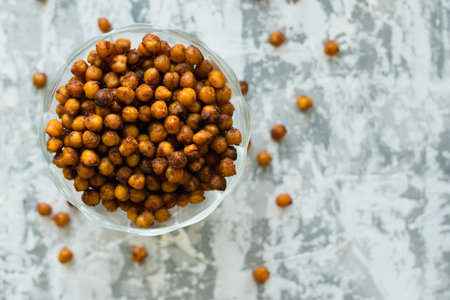 Delicious baked chickpeas in a transparent bowl on the table, on a light background with space for text flatlay. Healthy eating conceptの写真素材