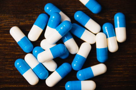 Many pills on a dark background macro. white and blue vitamin pills on a wooden background....