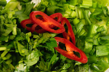 Red chili pepper sliced, green onion and parsley close-up.