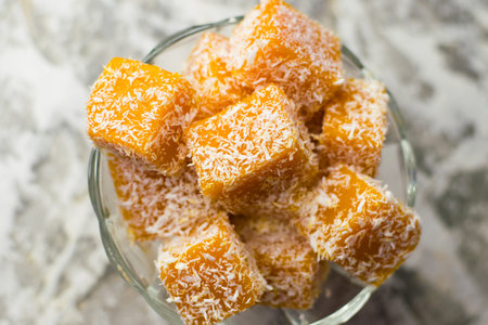 Sweet pumpkin dessert. Pumpkin and coconut marmalade in a transparent glass bowl on a light...
