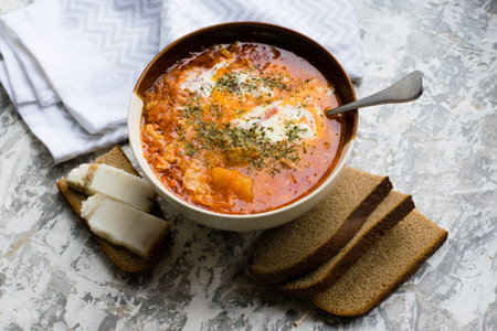 Delicious and aromatic red soup with meat, Ukrainian borscht with sour cream, dill and pieces of...