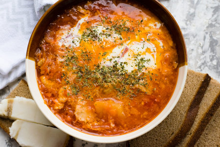Delicious and aromatic red soup with meat, Ukrainian borscht with sour cream, dill and pieces of...