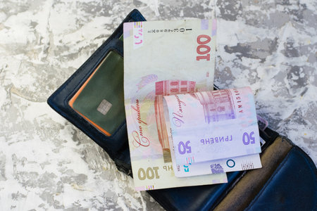 Old worn wallet with money and bank cards on a light background with space for text. Concept of...