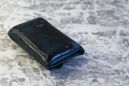 Old shabby wallet on a light background with space for text. Concept of poverty and financial...