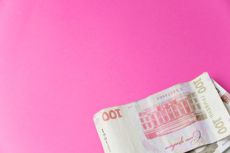 Paper money on pink paper background with space for text.
