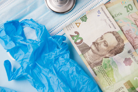 Money, medical mask, stethoscope, medical gloves on a blue background. Concept of medical expenses.