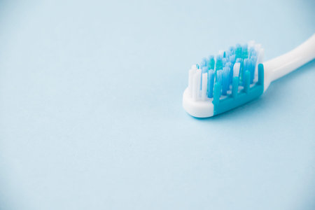 Blue toothbrush close up macro on light background.