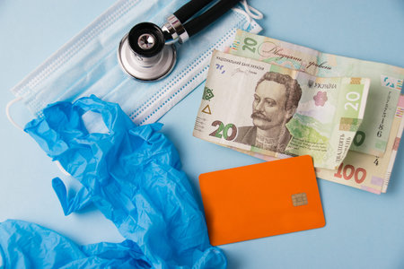 Money, credit card, medical mask, stethoscope, medical gloves on a blue background. Concept of...
