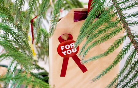Christmas gift with a message on the tree decoration warm toneの写真素材
