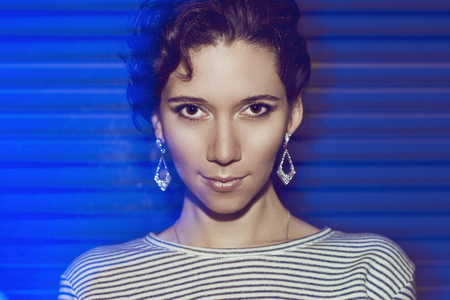 Portrait of a beautiful young brunette girl with evening make-up. The girl at a party in a nightclub.の写真素材