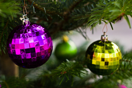 Violet and green glass balls on Christmas tree. New year and Christmas greeting card.の写真素材