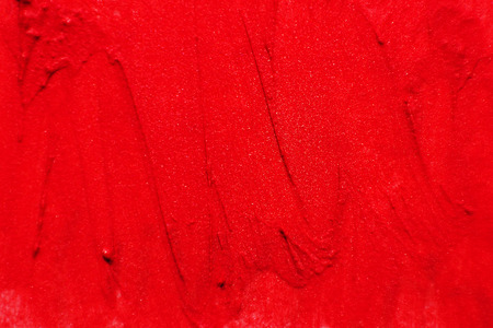 The texture of brush strokes of red lipstick. Background with dabs of red paint.の写真素材