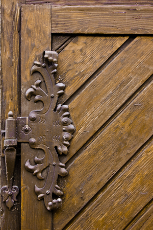 Vintage iron door hinges. Wrought iron hinges on the wooden door.の写真素材