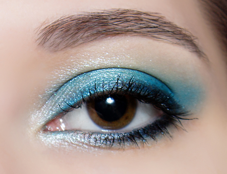 Brown eye makeup in close up. Make up trend: blue shiny eyeshadows.の写真素材