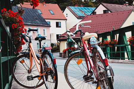 Two old bicycle on the bridge in vintage tinting. Romantic urban landscape in a small European town in Austria.の写真素材