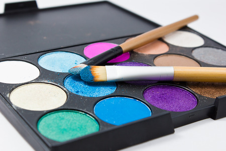 Brushes for make-up on the eye shadow palettes. Texture of crumbly  blue sparkling shadows.の写真素材