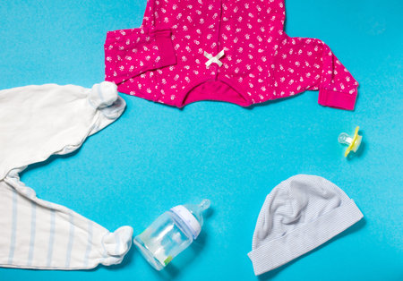 Children's clothing for the baby on a blue paper background. Preparing for motherhood. Shopping for pregnant women.の写真素材