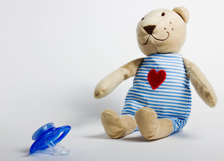 Baby bottles, pacifiers and toys lying on a white background. Kids' things.の写真素材