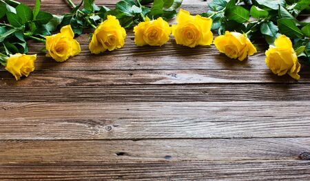 The bouquet of beautiful fresh yellow roses lies on a wooden table. Card template by St. Valentine's Day or the international Women's Day.の写真素材