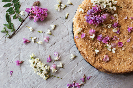 Homemade biscuit cake with caramel cream, decorated with fresh flowers. Top view of a biscuit cake.の写真素材