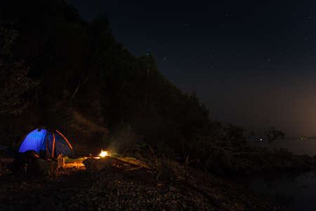 Tent campfire, camping by the riverの写真素材