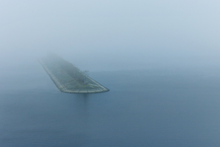 Lighthouse in a foggy sea. Dark dayの写真素材
