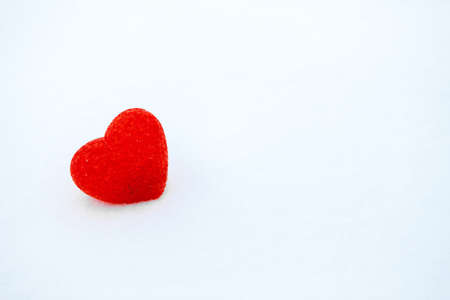 Red textured heart lies on the snow. Valentine's dayの写真素材