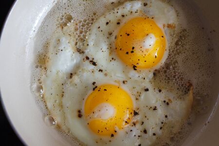 fried eggs from 2 eggs in a frying pan. Hot Sunny dishの写真素材