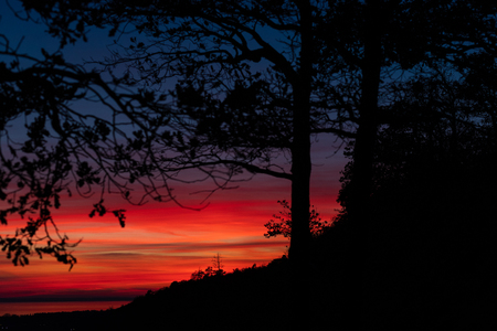 Beautiful and colorful sunset over the forest and riverの写真素材