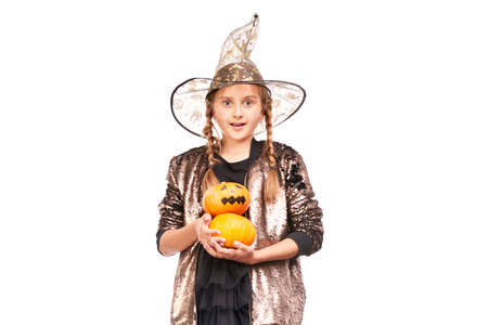 Studio portrait of little girl posing with jack-o-lantern against white backgroundの写真素材