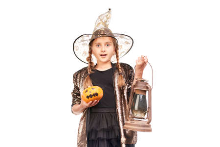 Studio portrait of little girl posing with jack-o-lantern against white backgroundの写真素材