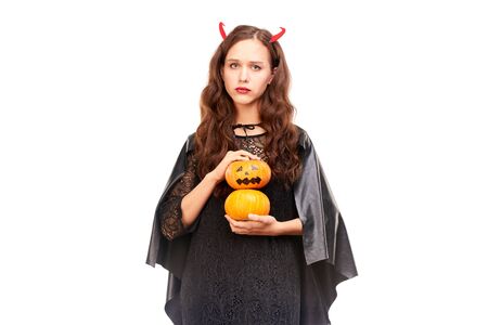 Young woman in Halloween costume posing against white background in studioの写真素材