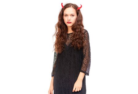Young woman in Halloween costume posing against white background in studioの写真素材