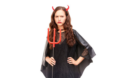 Young woman in Halloween costume posing against white background in studio