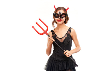 Portrait of beautiful she-devil posing with trident on Halloween against white backgroundの写真素材