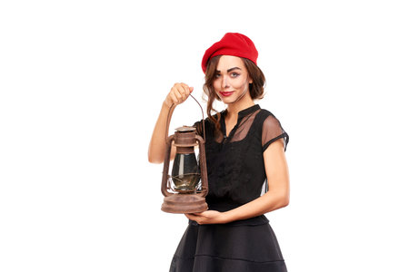 Studio portrait of young woman in Halloween costume posing with lanternの写真素材