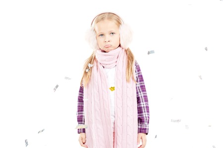 Portrait of little girl wearing scarf and winter ear muffs on white backgroundの写真素材