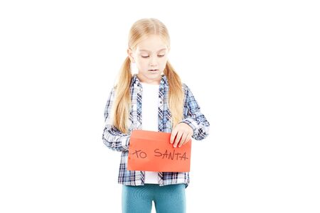 Portrait of little girl holding envelope with letter to Santaの写真素材