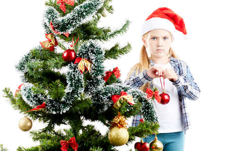 Studio portrait of little girl decorating Christmas treeの写真素材