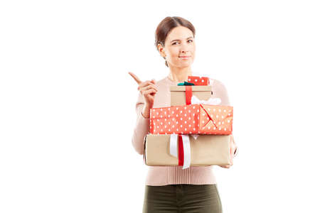 Portrait of young woman holding stack of Christmas giftsの写真素材
