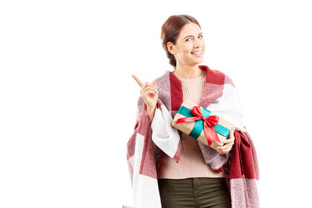 Portrait of woman wrapped in blanket holding Christmas giftの写真素材