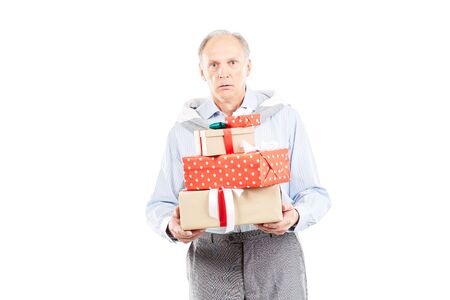 Portrait of senior man holding heap of Christmas giftsの写真素材