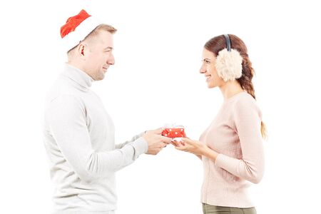 Studio portrait of man and woman with Christmas present on white backgroundの写真素材