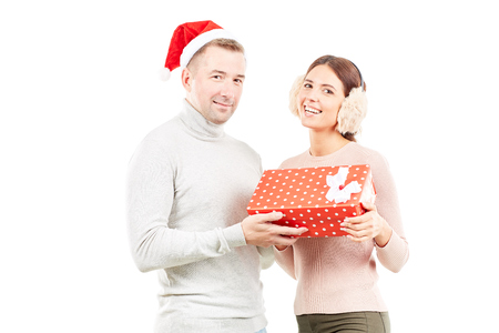 Studio portrait of man and woman with Christmas present on white backgroundの写真素材