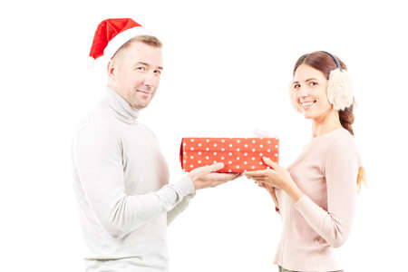 Studio portrait of man and woman with Christmas present on white backgroundの写真素材